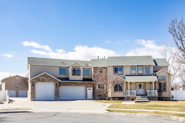 view of front of home featuring stucco siding, stone siding, concrete driveway, a front yard, and a garage