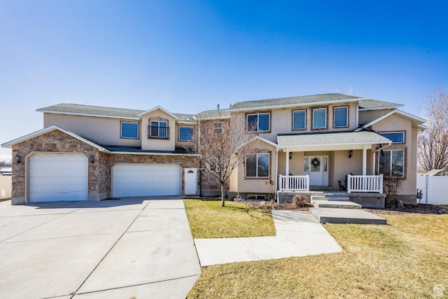 view of front of house with a porch, concrete driveway, a front yard, stucco siding, and an attached garage