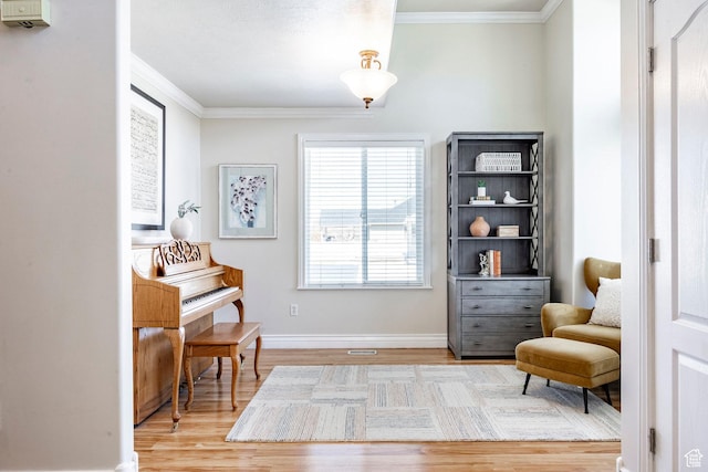 sitting room featuring baseboards, wood finished floors, and ornamental molding