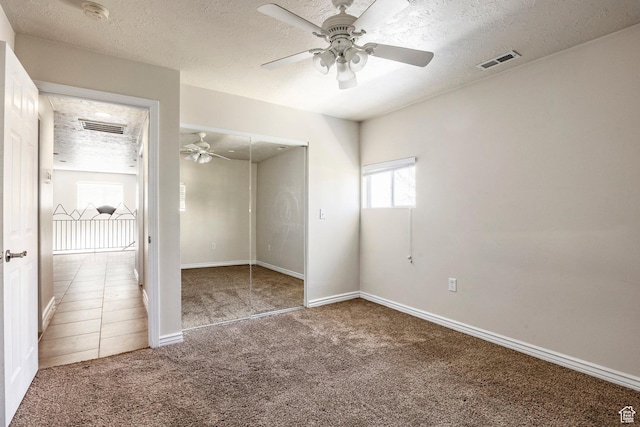 unfurnished bedroom with visible vents, carpet floors, and a textured ceiling