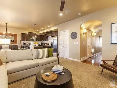 carpeted living area with recessed lighting, arched walkways, and baseboards