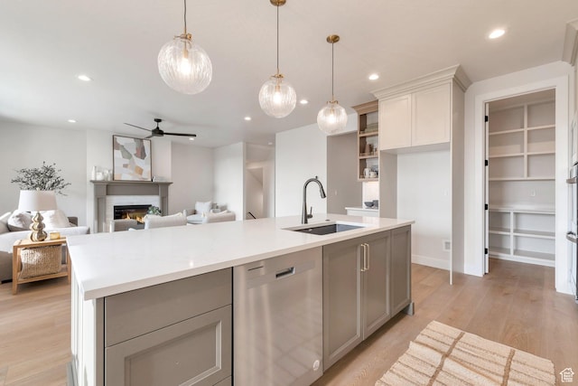 2123 N 520 W, Centerville, UT 84014 - kitchen with a sink, light countertops, gray cabinets, stainless steel dishwasher, and a lit fireplace