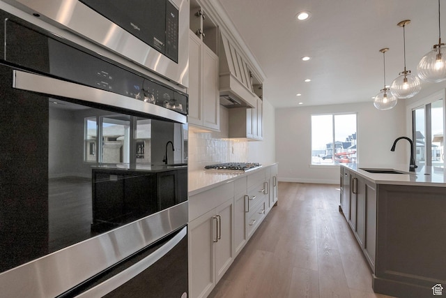 2123 N 520 W, Centerville, UT 84014 - kitchen featuring a sink, light wood finished floors, stainless steel appliances, baseboards, and recessed lighting