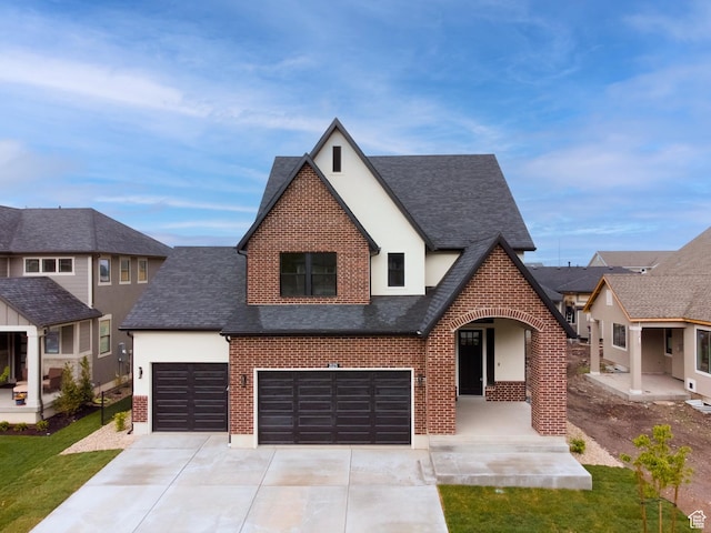 view of front of house featuring roof with shingles, driveway, and brick siding
