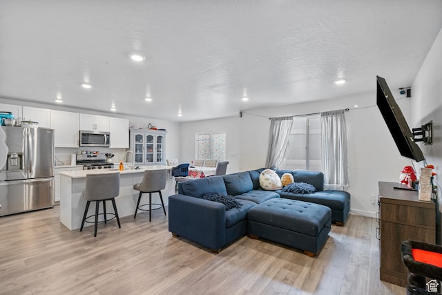 1027 E Reef Dr, Saratoga Springs, UT 84045 - living area with recessed lighting, light wood-style floors, and a textured ceiling