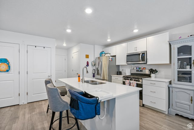 1027 E Reef Dr, Saratoga Springs, UT 84045 - kitchen featuring a breakfast bar area, a kitchen island with sink, a sink, light wood-style floors, and appliances with stainless steel finishes