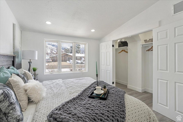 7046 S 2955 E, Cottonwood Heights, UT 84121 - bedroom featuring visible vents, a textured ceiling, vaulted ceiling, and wood finished floors