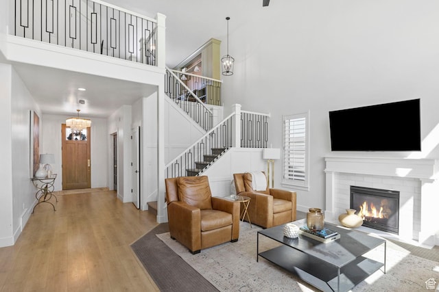 764 E 760 S, Pleasant Grove, UT 84062 - living area with a notable chandelier, wood finished floors, stairway, a high ceiling, and a brick fireplace