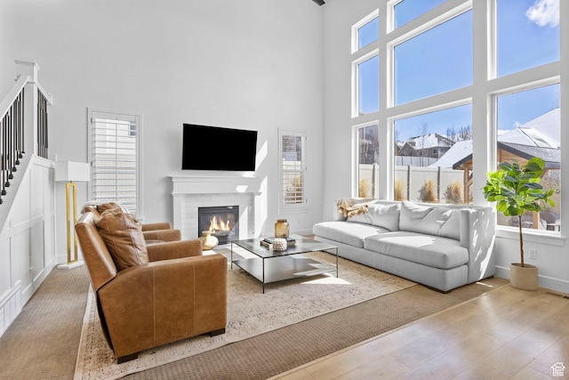 764 E 760 S, Pleasant Grove, UT 84062 - living room featuring wood finished floors, a high ceiling, baseboards, a brick fireplace, and stairs