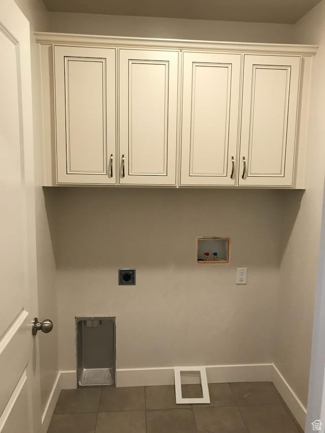 laundry area with electric dryer hookup, visible vents, dark tile patterned flooring, washer hookup, and cabinet space