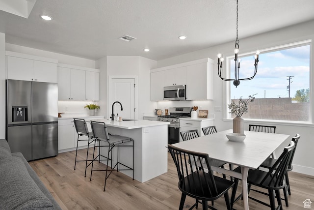 336 W Rosie Loop Unit 45W, Cedar City, UT 84721 - kitchen with stainless steel appliances, a sink, a kitchen island with sink, a kitchen bar, and recessed lighting