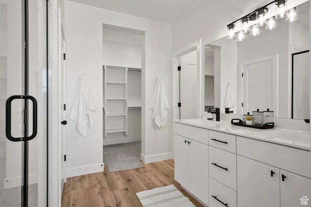 336 W Rosie Loop Unit 45W, Cedar City, UT 84721 - bathroom featuring wood finished floors, baseboards, a walk in closet, double vanity, and a stall shower