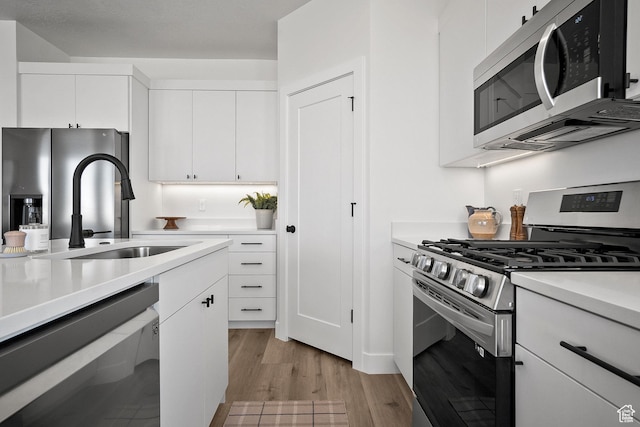 336 W Rosie Loop Unit 45W, Cedar City, UT 84721 - kitchen featuring stainless steel appliances, a sink, light countertops, light wood-style floors, and white cabinets