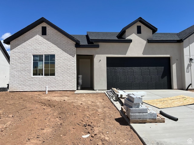 336 W Rosie Loop Unit 45W, Cedar City, UT 84721 - view of front of house with a garage, concrete driveway, and stone siding