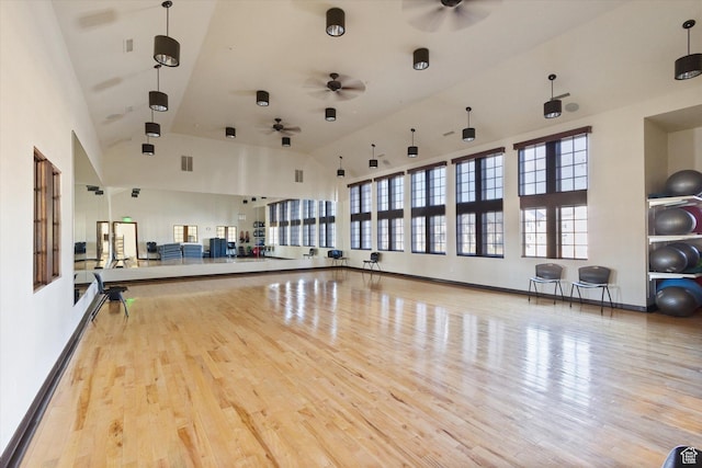 workout area featuring high vaulted ceiling, wood finished floors, a ceiling fan, and baseboards