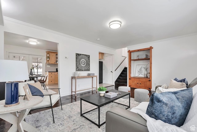 living room with crown molding, baseboards, wood finished floors, and stairway