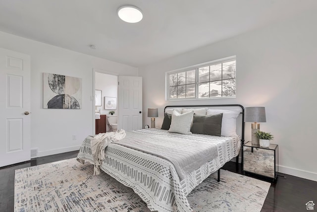 bedroom featuring baseboards, connected bathroom, wood finished floors, and visible vents