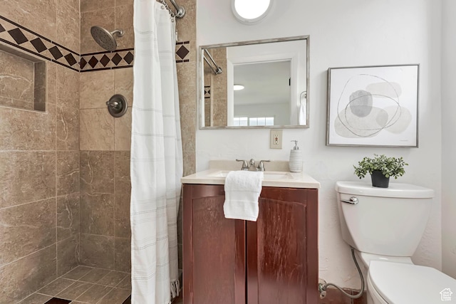 full bathroom with vanity, toilet, and tiled shower