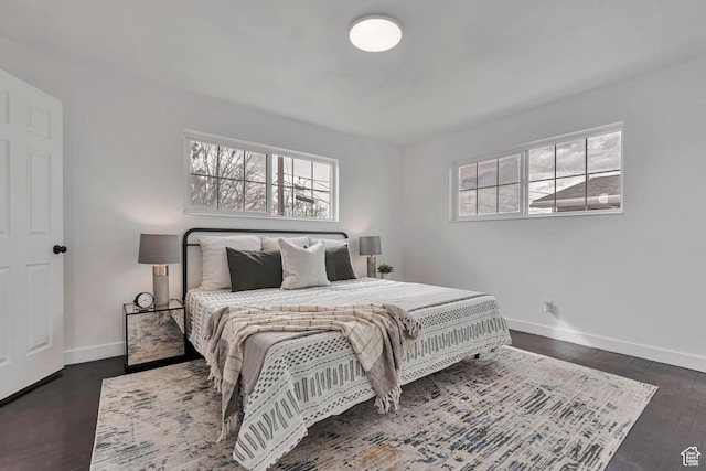 bedroom featuring baseboards and dark wood-type flooring