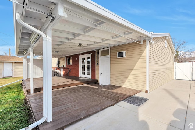 exterior space with an outdoor structure, fence, french doors, a storage unit, and a gate