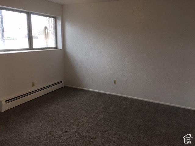 301 W 500 N, Logan, UT 84321 - unfurnished room featuring a baseboard radiator and dark colored carpet