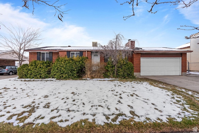 ranch-style house featuring brick siding, an attached garage, concrete driveway, and a chimney
