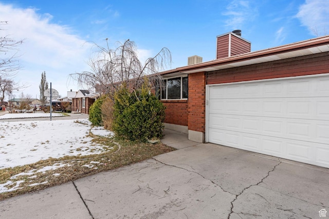 5623 Brandy Wine St, Taylorsville, UT 84118 - view of front of home featuring a garage, brick siding, concrete driveway, and a chimney