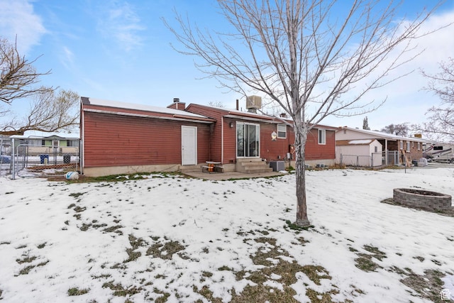 5623 Brandy Wine St, Taylorsville, UT 84118 - snow covered back of property featuring central AC, a chimney, and fence