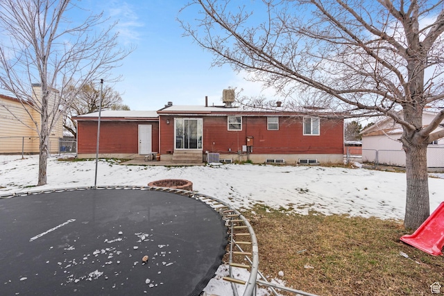 5623 Brandy Wine St, Taylorsville, UT 84118 - snow covered rear of property featuring entry steps, central AC, and fence