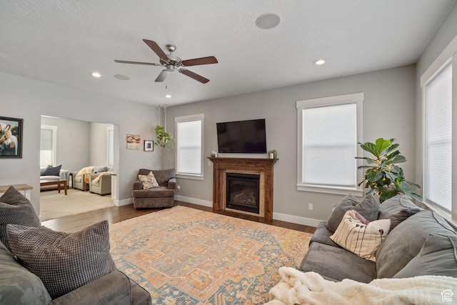 2558 Mountain Glen Rd, Erda, UT 84074 - living room featuring a ceiling fan, wood finished floors, a glass covered fireplace, recessed lighting, and baseboards
