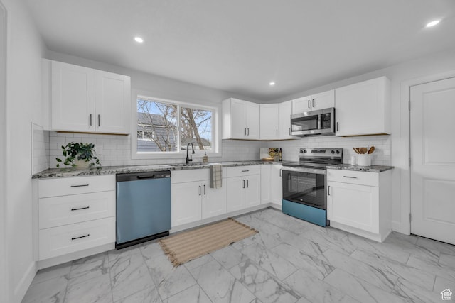 590 E 7th St, Ogden, UT 84404 - kitchen featuring light stone countertops, appliances with stainless steel finishes, white cabinets, marble finish floor, and a sink