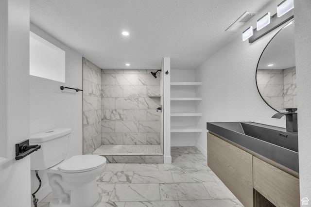 590 E 7th St, Ogden, UT 84404 - bathroom featuring visible vents, toilet, marble finish floor, a textured ceiling, and tiled shower