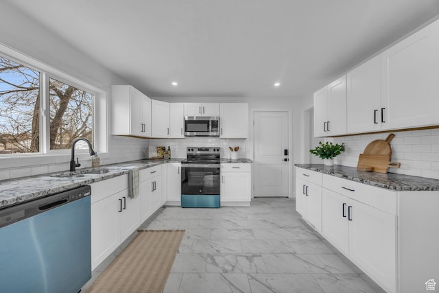 590 E 7th St, Ogden, UT 84404 - kitchen with marble finish floor, a sink, dark stone countertops, appliances with stainless steel finishes, and white cabinets