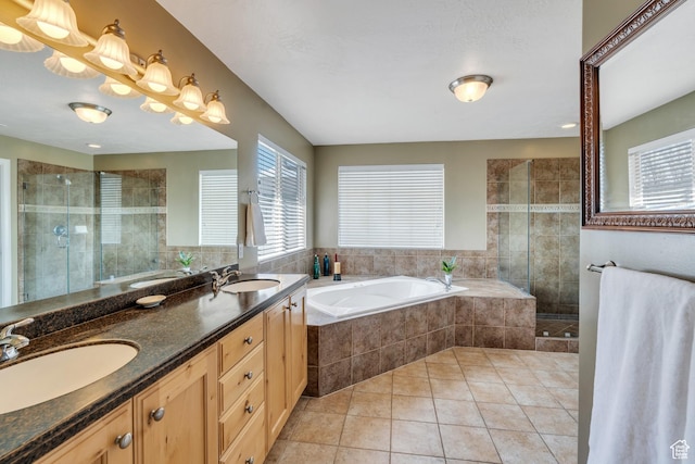 full bathroom featuring a shower stall, tile patterned flooring, a bath, and a sink