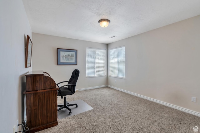 carpeted office featuring visible vents, baseboards, and a textured ceiling