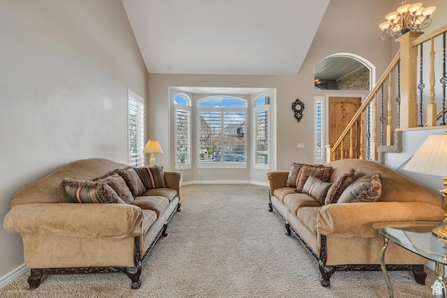 living area with carpet floors, baseboards, high vaulted ceiling, and an inviting chandelier
