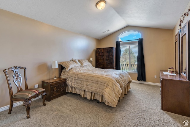 bedroom featuring baseboards, vaulted ceiling, a textured ceiling, visible vents, and light colored carpet