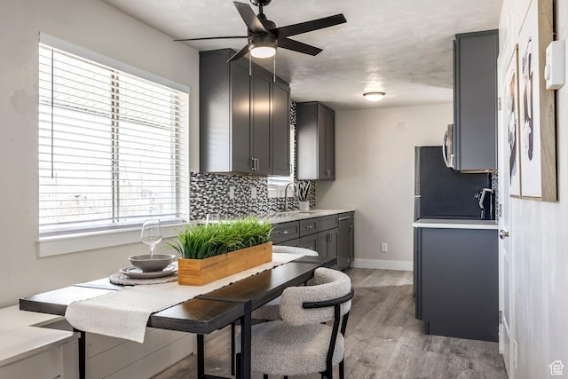 3061 W 13800 S, Bluffdale, UT 84065 - kitchen featuring light wood-style floors, light countertops, decorative backsplash, baseboards, and ceiling fan