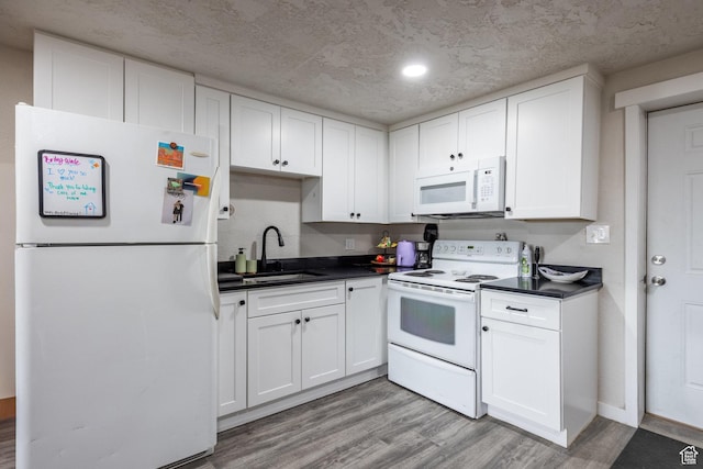 3061 W 13800 S, Bluffdale, UT 84065 - kitchen with white appliances, light wood finished floors, a sink, white cabinetry, and dark countertops