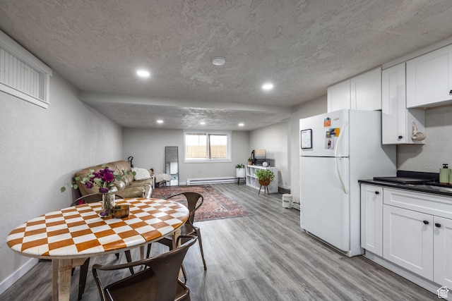 3061 W 13800 S, Bluffdale, UT 84065 - dining space with a baseboard radiator, baseboards, a textured ceiling, and wood finished floors