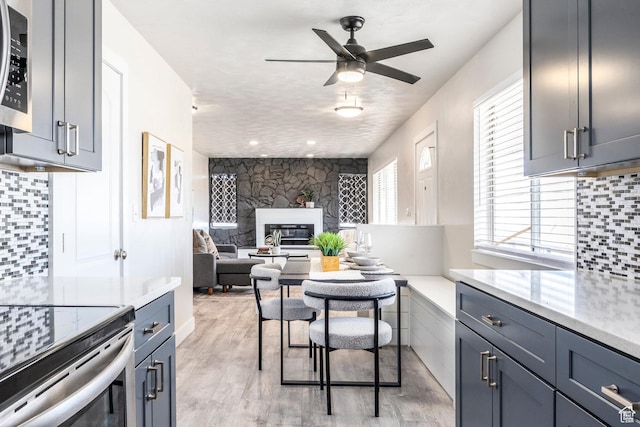 3061 W 13800 S, Bluffdale, UT 84065 - dining room with a glass covered fireplace, light wood-style flooring, and a ceiling fan