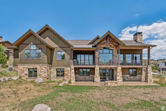1075 N Oquirrh Mountain Dr Unit 64, Heber City, UT 84032 - back of house featuring stone siding, a standing seam roof, a patio area, and a chimney