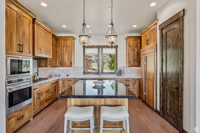 1075 N Oquirrh Mountain Dr Unit 64, Heber City, UT 84032 - kitchen with built in appliances, a chandelier, recessed lighting, a breakfast bar area, and dark stone counters