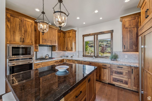 1075 N Oquirrh Mountain Dr Unit 64, Heber City, UT 84032 - kitchen featuring stainless steel appliances, tasteful backsplash, a chandelier, brown cabinetry, and recessed lighting