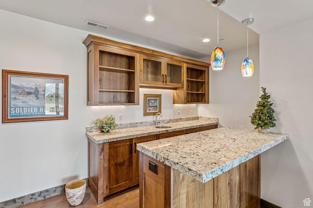 1075 N Oquirrh Mountain Dr Unit 64, Heber City, UT 84032 - kitchen with open shelves, brown cabinets, light wood-type flooring, hanging light fixtures, and a peninsula