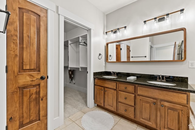 bathroom with a sink, double vanity, and tile patterned floors