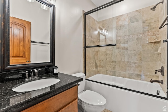bathroom with vanity, toilet, and shower / bath combination with glass door