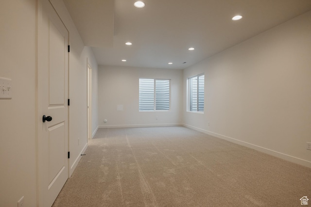 spare room with recessed lighting, baseboards, and light colored carpet