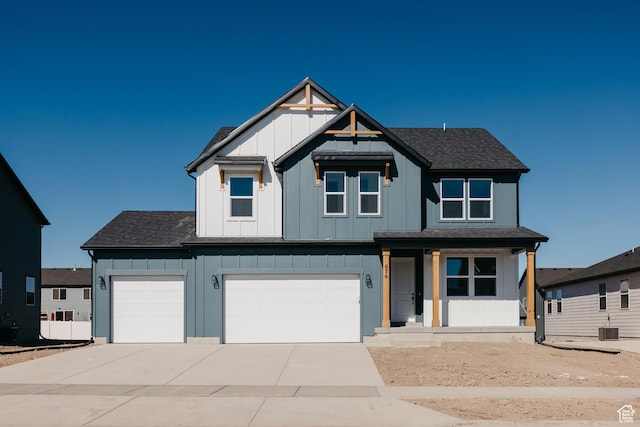 view of front of property featuring board and batten siding, a shingled roof, an attached garage, cooling unit, and driveway
