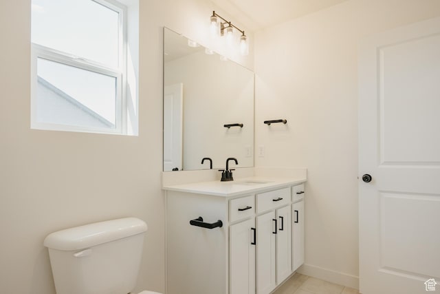 bathroom with toilet, vanity, and tile patterned floors